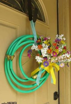 a bunch of flowers that are sitting in front of a door with some hoses attached to it