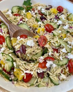 a salad with cucumbers, tomatoes, and feta cheese in a white bowl