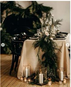 the table is set with candles and greenery