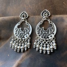 These Boho Silver Dangle Earrings with Beaded Fringe offer a unique blend of elegance and bold style. Featuring a distinctive Ethnic Floral Drop Design, the earrings are adorned with a beaded fringe that adds a playful yet sophisticated movement to their look. Perfect for those who appreciate Vintage Style Statement Jewelry, these earrings are ideal for women who love to mix bohemian and ethnic influences in their wardrobe, enhancing both casual everyday outfits and more refined, eclectic ensemb Vintage Festival Earrings With Dangling Beads, Bohemian Metal Chandelier Earrings For Festivals, Bohemian Chandbali Beaded Jewelry, Bohemian Beaded Chandbali Jewelry, Bohemian Chandbali Beaded Earrings For Festive Occasions, Bohemian Tassel Earrings With Latkans For Festivals, Bohemian Dangle Earrings For Festive Occasions, Bohemian Metal Earrings With Latkans, Festive Bohemian Dangle Plug Earrings