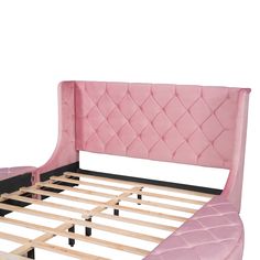 a pink bed frame with wooden slats and foot board in the shape of a headboard