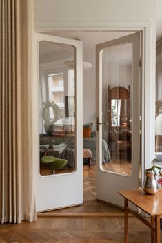 an open door leading to a living room with a couch and table in front of it