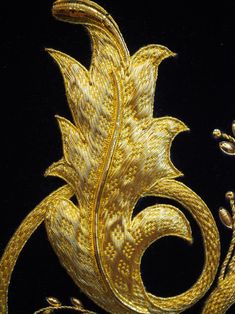 a gold brooch with leaves and flowers on it