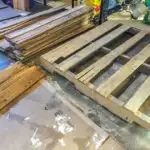 several wooden pallets stacked on top of each other in a room filled with tools