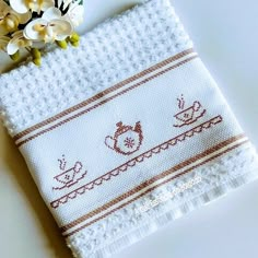 a white towel with some flowers on top of it