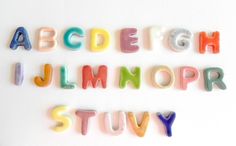 the letters are made up of candy in different colors and font styles on a white surface