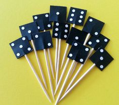 black and white polka dot picks with toothpicks on yellow table cloth background, ready to be used for party favors