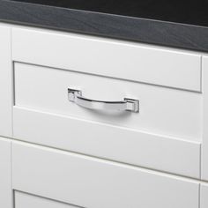 a close up of a drawer on a white cabinet with black counter top and drawers