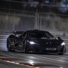 a black sports car driving on a track at night