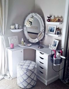 a vanity with a mirror, stool and pictures on the wall