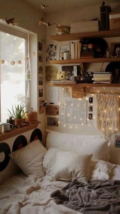 a bedroom with lots of lights and pictures on the wall above the bed, along with bookshelves