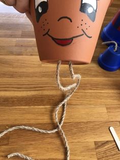 a pot with a face drawn on it is being held by someone's hands