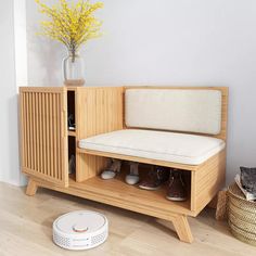 a wooden bench with shoes on it in front of a white wall