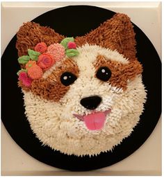 a cake made to look like a dog with flowers on it's head and tongue