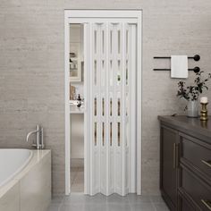 a bathroom with a tub, sink and large white door that opens to the outside