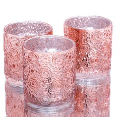 four pink glass tumblers sitting next to each other