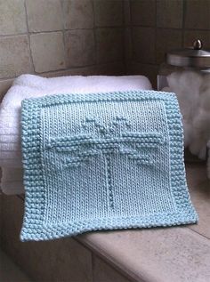 a crocheted blue blanket sitting on top of a window sill next to towels