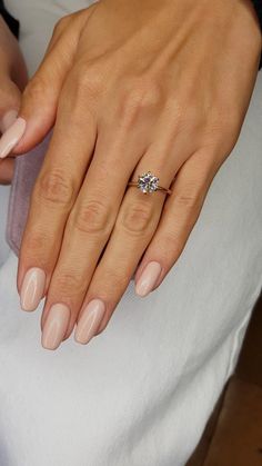 a woman's manicured nails with a ring on her finger and an engagement band