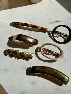 A collection of vintage french  barrette's. all sold separately . made in France etched. An amazing vintage condition clasp still works beautifully. 1. 1990s long thin tortoisse shell barrette.   Made In Oyonnax France  2. 1980s cream pearlescent oval barrette with little teeth on clip part to stay secure while in hair.  3. 1980s bronze oval barrette with little teeth on clip part to stay secure while in hair.  4. 1980s gold chain mail and  rhinestone hair comb barrette 3" Unbranded Hair Clip Collection, Vintage Hair Barrettes, French Hair Clip, Clips In Hair, 2024 Accessories, Gold Hair Clip, Rhinestone Hair Comb, Vintage Hair Clips, French Barrette