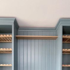 a room with blue walls and wooden shelves