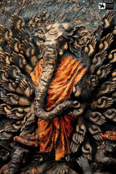 an image of a person covered in fire and mud with their hands on the ground