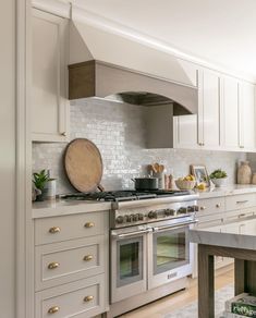 a kitchen with an oven, stove and table in front of the counter top area