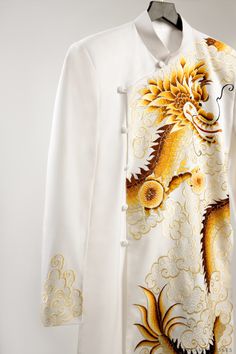 Our Han white groom ao dai jacket with a custom dragon embroidery design is the perfect stylish, modern piece to wear on your wedding day. With stunning embroidery detailing at the wrists and a fierce dragon design, this jacket does the talking all by itself! Look and feel fierce on your special day, and make an unforgettable impression in Han. Details: Vietnamese Groom Ao Dai jacket Custom embroidery Dragon Long sleeves Embroidery at wrists Front closure with fabric buttons Made to your own mea Fierce Dragon, Vietnamese Ao Dai, Dragon Embroidery, Sleeves Embroidery, Embroidery Detailing, Fabric Buttons, Dream Dresses, Dragon Design, Custom Embroidery