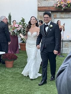 a bride and groom walking down the aisle