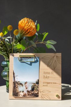 a wooden frame with an image and flowers in it