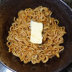 a brown bowl filled with noodles and cheese