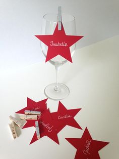 wine glass with red stars hanging from the side and name tags attached to the bottom