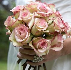 a bride holding a bouquet of pink roses