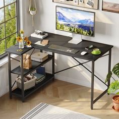 a computer desk in front of a window with pictures on the wall above it and a potted plant next to it