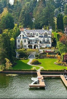 an aerial view of a house on the water with a dock in front of it