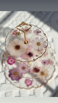 a glass plate with flowers on it sitting on a table