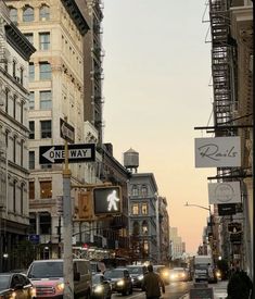 a city street filled with lots of traffic and tall buildings on either side of it