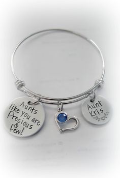 "Hand-Stamped Personalized Aunt Bangle Bracelet Bracelet features two custom-stamped discs along with an open heart charm and a Swarovski birthstone drop. Fashioned on an expandable stainless steel bangle bracelet. The fully adjustable bangle measures 60mm and fits wrists 7-8\" Comes in either an organza pouch or a giftbox depending upon which option you select. ♦ ♦ ♦ ♦ ♦ ♦ ♦ ♦ ♦ ♦ ♦ ♦ ♦ ♦ ♦ ♦ ♦ ♦ Only one side can be stamped as it shows through on reverse side. ♦ ♦ ♦ ♦ ♦ ♦ ♦ ♦ ♦ ♦ ♦ ♦ ♦ ♦ ♦ ♦ ♦ Harley Davidson Gifts, Best Auntie Ever, Motorcycle Keychain, You Are Precious, Organza Pouch, Stainless Steel Bangles, Adjustable Bangle, Open Heart, Birthstone Jewelry