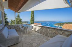 an outdoor patio with white furniture overlooking the ocean