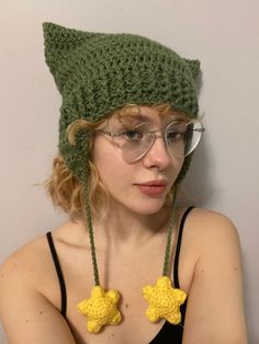 a woman wearing glasses and a knitted green hat with yellow stars on the front