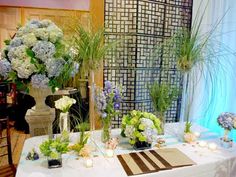 the table is set up with flowers and greenery for an elegant wedding or special event