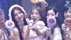 girls singing into microphones while holding candy lollipops