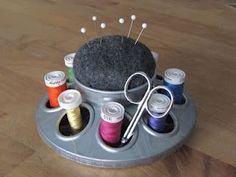 an assortment of sewing thread and needles on a tray