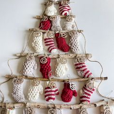 a christmas tree made out of crocheted stockings and mittens hanging from branches