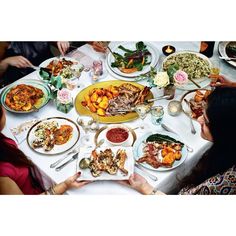 a wooden table topped with plates filled with food