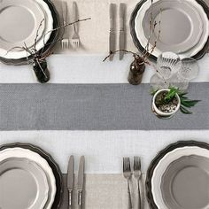 the table is set with silverware and place settings