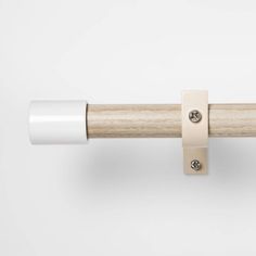 a close up of a wooden handle on a white curtain rod with two metal studs