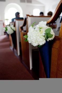 a bouquet of white flowers sitting on the pews of a church