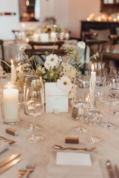 the table is set with silverware and candles