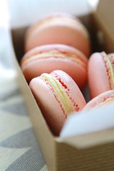 some pink macaroons are in a box