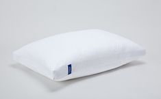 a white pillow sitting on top of a gray surface